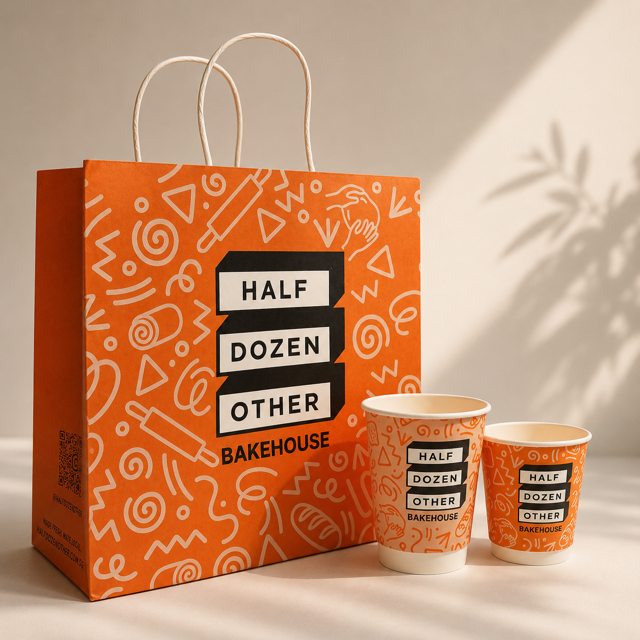 Half Dozen Other Bakehouse branded carrier bag with matching paper cups
